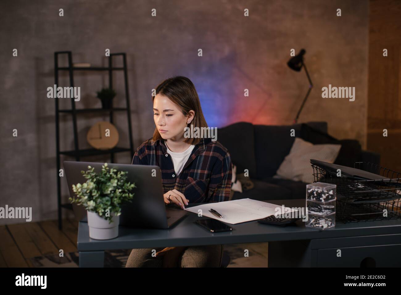 Asian ragazza trader che lavora su un portatile a casa Foto Stock