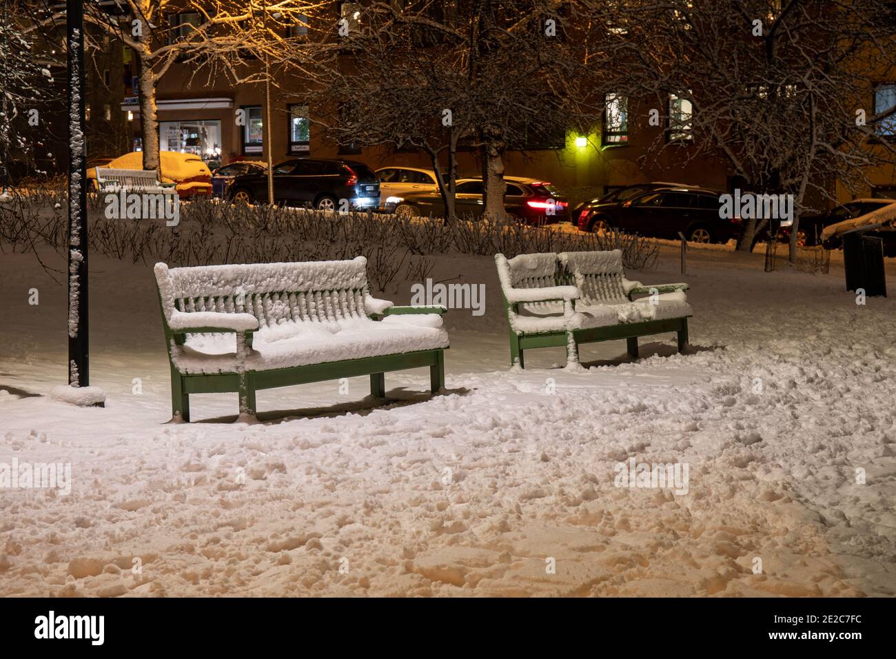 Panchine del parco coperte di neve nel quartiere Taka-Töölö di Helsinki, Finlandia Foto Stock