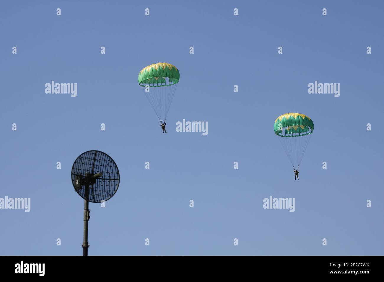 Paracadute militari paracadutisti saltano in cielo blu dal giorno della cerimonia dell'aeroplano. Forze armate esercizio speciale del personale di battaglione. Difesa nazionale con Foto Stock