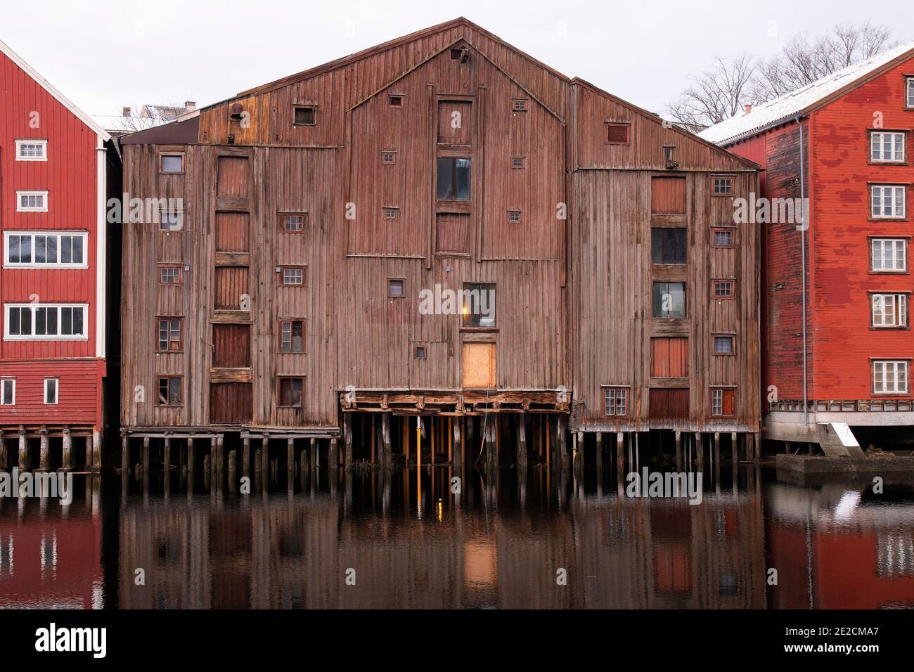 Vecchi magazzini in legno sul fiume Nidelva, Trondheim, Norvegia. Quello al centro è stato costruito in almeno tre fasi come più spazio era necessario Foto Stock
