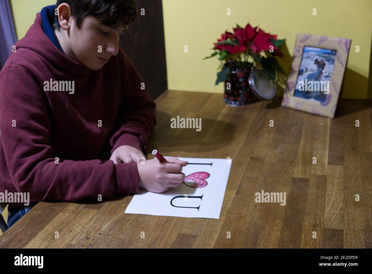Il ragazzo caucasico dedica un disegno con le parole Io amo U alla ragazza amata Foto Stock