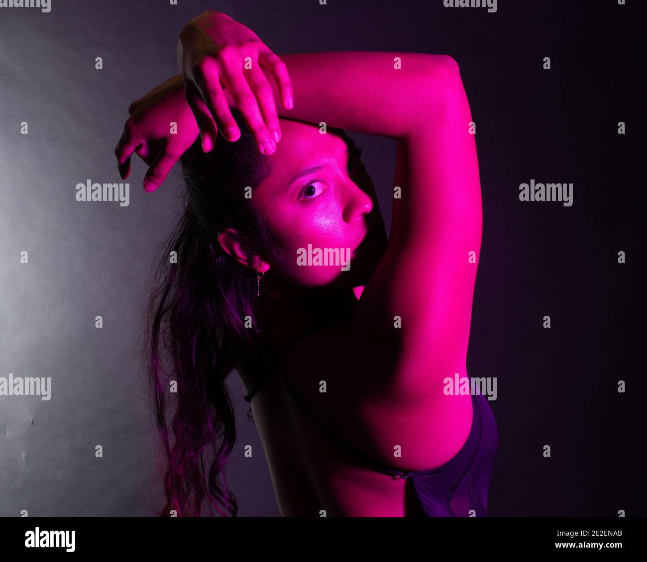 Bella e colorata tonalità rosa su un modello femminile posato E Studio artistico Ritratto Foto Stock