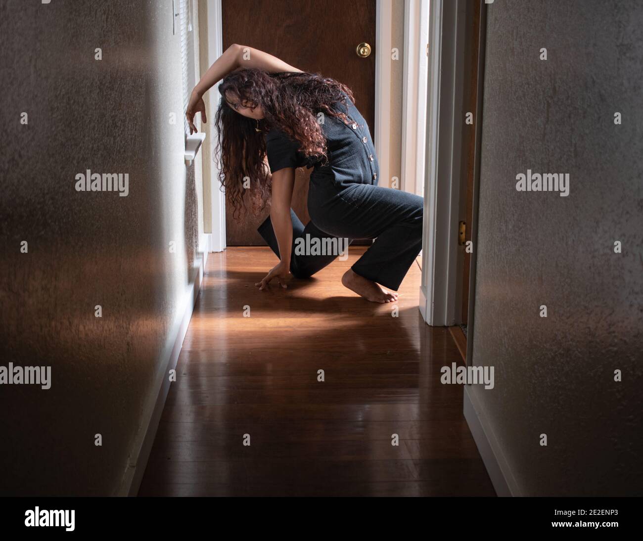 Bella e aggraziata Donna Danze e posa attraverso il movimento in Un corridoio interno Foto Stock