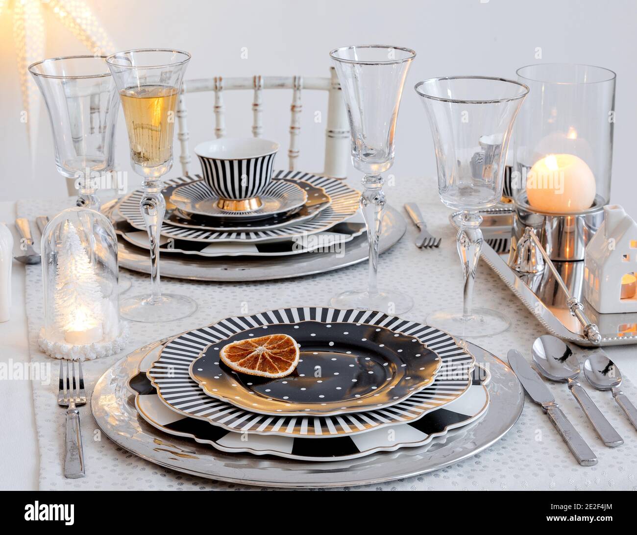 Elegante tavolo con set di piatti bianchi e neri, bicchieri da