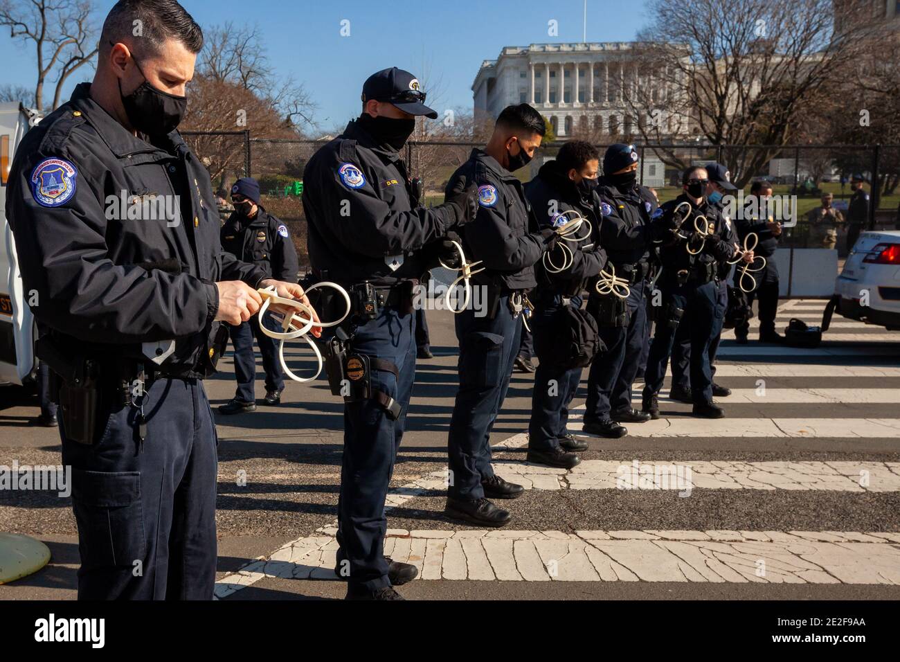 Washington, DC, USA, 13 gennaio 2021. Nella foto: Capitol Police OFC. Joseph Rudiger e i suoi colleghi preparano manette di plastica per un gruppo pacifico di 30 persone in un'area pubblica aperta durante la protesta di tutti i fascisti dell'espulsione di Shutdown DC. I manifestanti hanno scritto i nomi dei rappresentanti e dei senatori che si sono opposti alla certificazione dei risultati delle elezioni presidenziali il 6 gennaio su tre grandi bandiere. Hanno cercato di esibire i banner, ma sono stati cacciati dalla polizia che violava i loro diritti di primo emendamento. Credit: Alison C Bailey/Alamy Live News Foto Stock