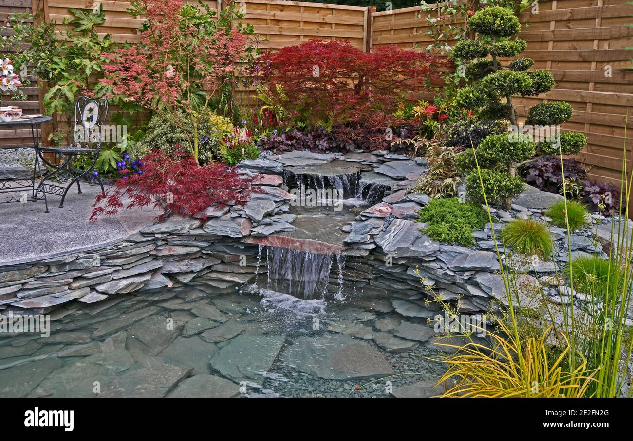 Una roccia naturale e giardino d'acqua witrh potatura nuvolosa e. Acer a colori Foto Stock