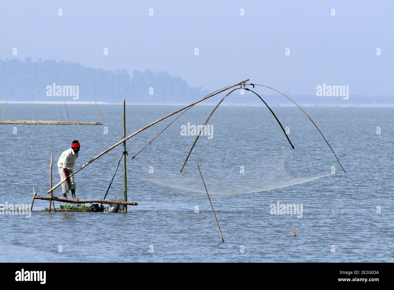 Pescatore con rete sul fiume Brahmaputra, Assam, India Foto Stock