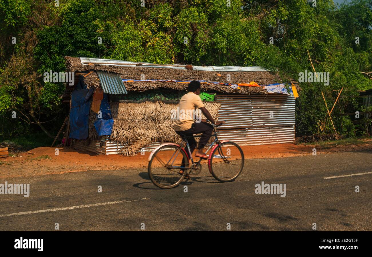 Uomo in bicicletta di fronte a un sacco di corsa. sud-est asiatico Foto Stock