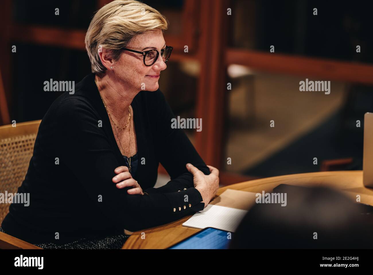 Donna adulta di successo seduta a una riunione con i colleghi in sala riunioni. donna d'affari in sala conferenze. Foto Stock