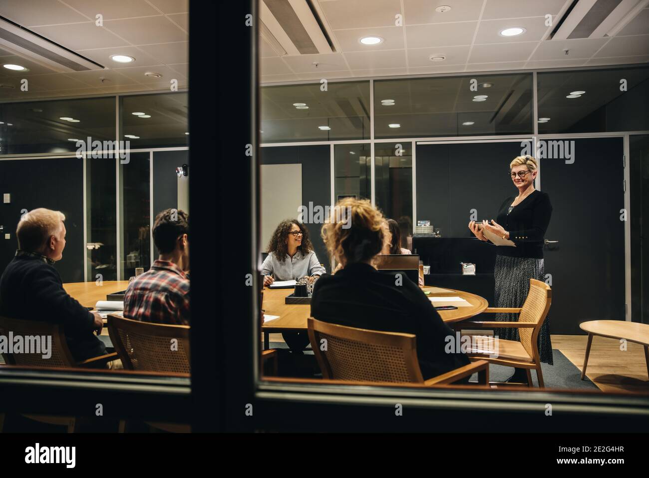 uomini d'affari all'interno di una moderna sala riunioni. Donna in piedi e dirige una riunione d'affari. Foto Stock