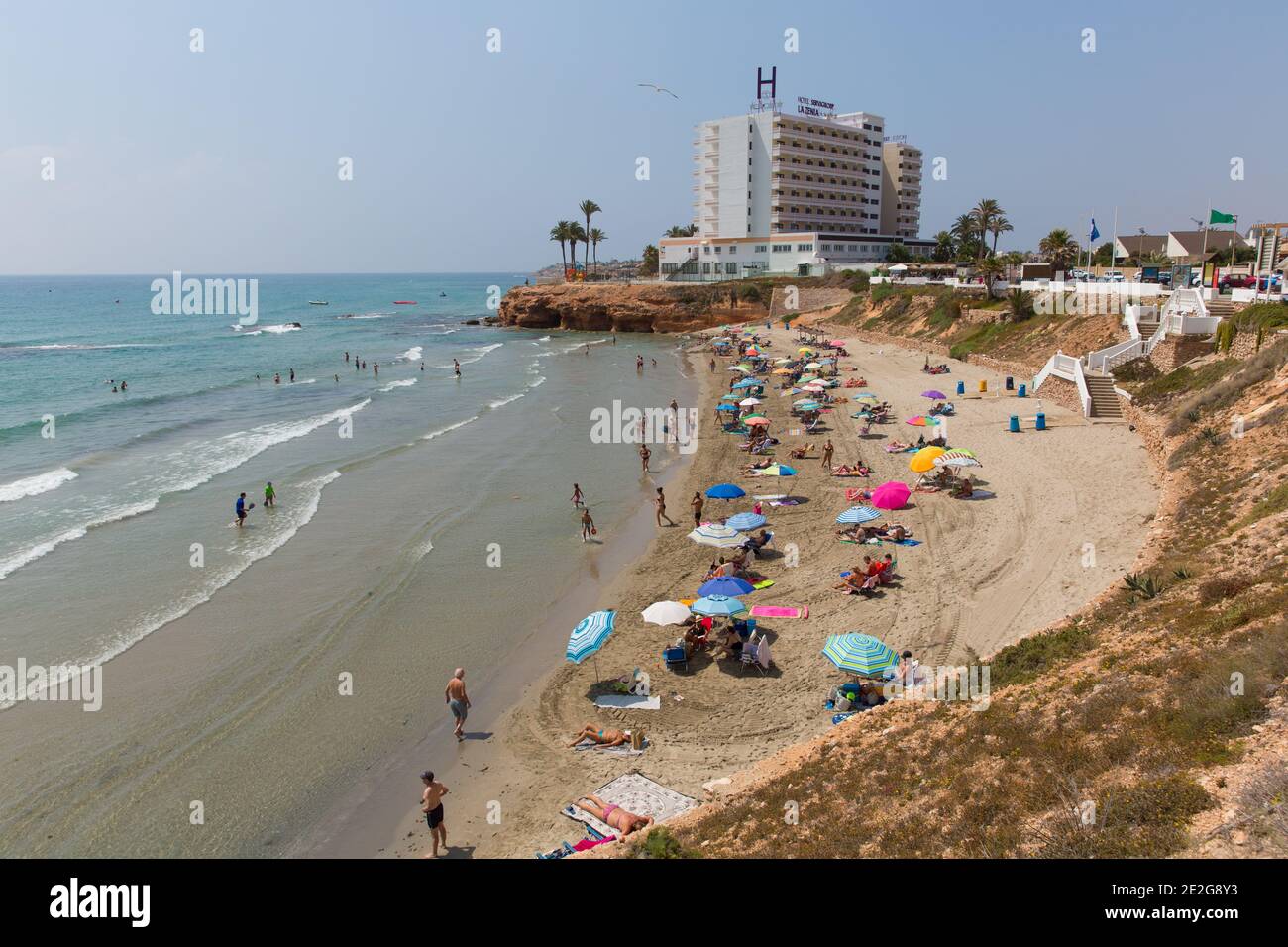 Playa Cala Cerrada Orihuela Spagna peoiple sulla spiaggia vicino a Los Angeles Zenia sotto il sole estivo Foto Stock