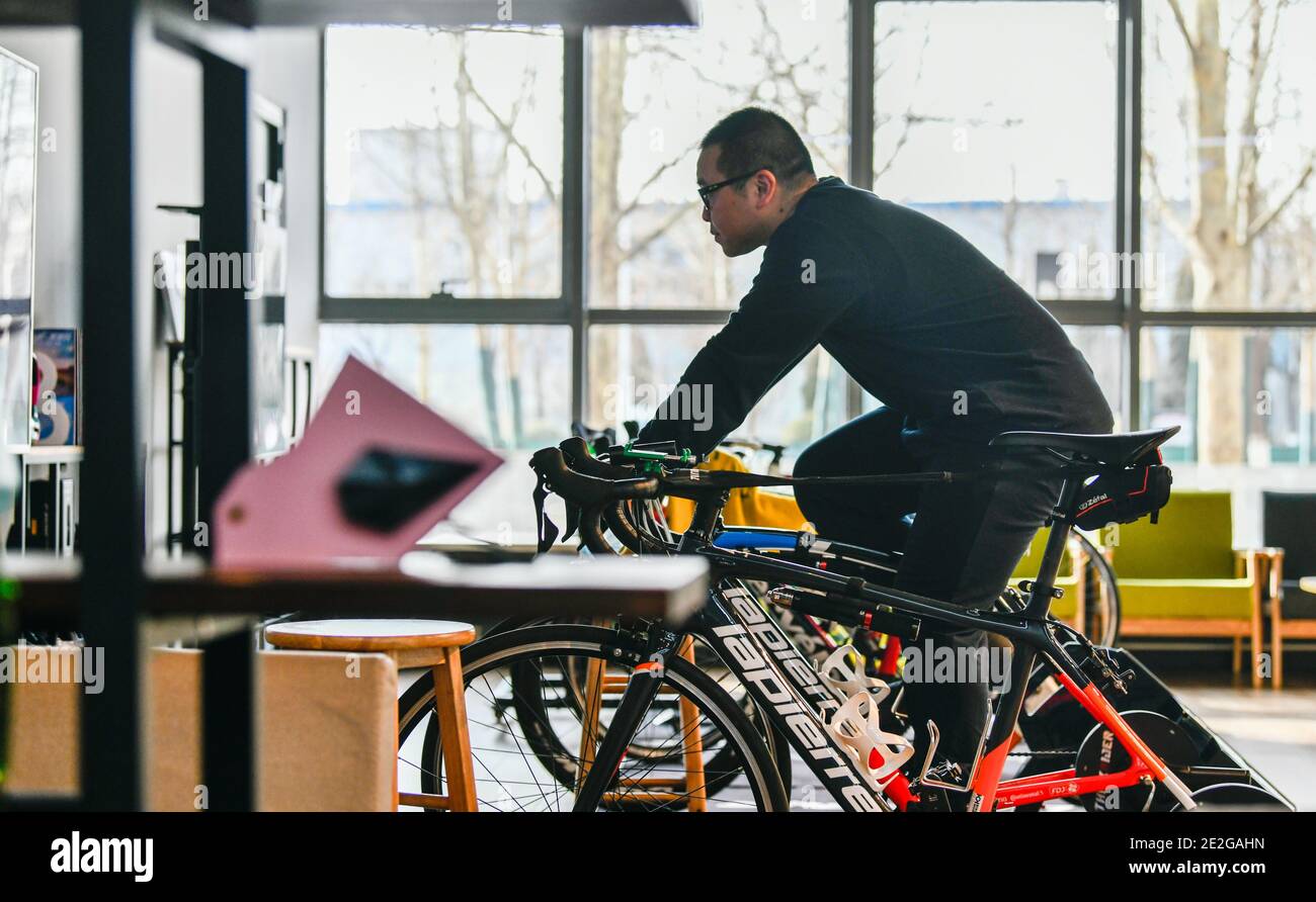 Tianjin, distretto di Wuqing nel nord della Cina, Tianjin. 13 gennaio 2021.  Un cliente sperimenta il ciclismo in Bike Work, una sala di esperienza  dello stile di vita in bicicletta, nel distretto