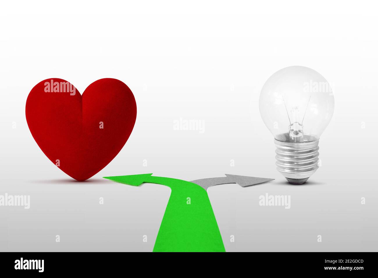 Frecce a due vie con cuore e lampadina - concetto di scelta del cuore sopra la mente Foto Stock Frecce a due vie con cuore e lampadina - concetto di scelta del cuore sopra la mente Foto Stock