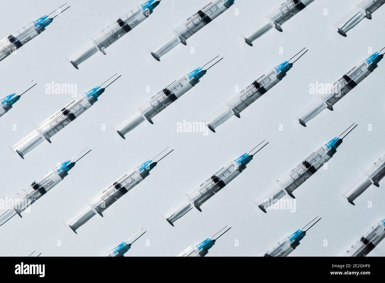 Siringhe di vaccino COVID-19 su sfondo blu Foto Stock