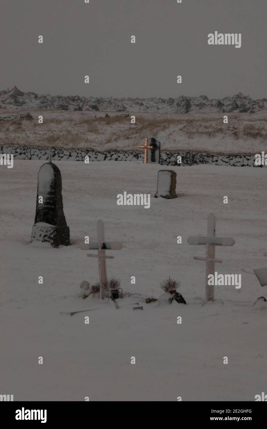 Sepolcri e croci del cimitero innevato, Budir, Islanda Foto Stock