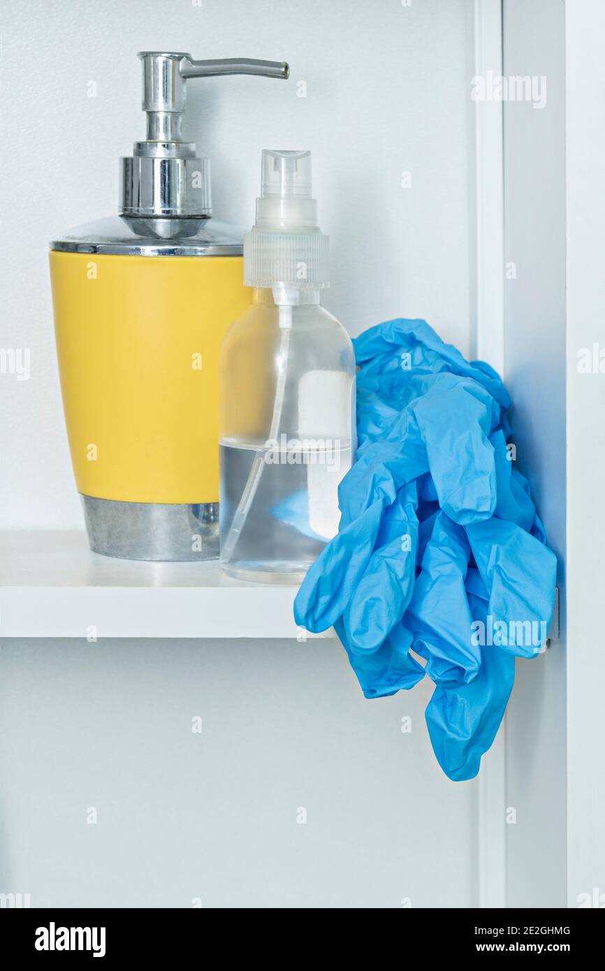 Guanti protettivi sul ripiano del bagno con sapone e disinfettante Foto Stock