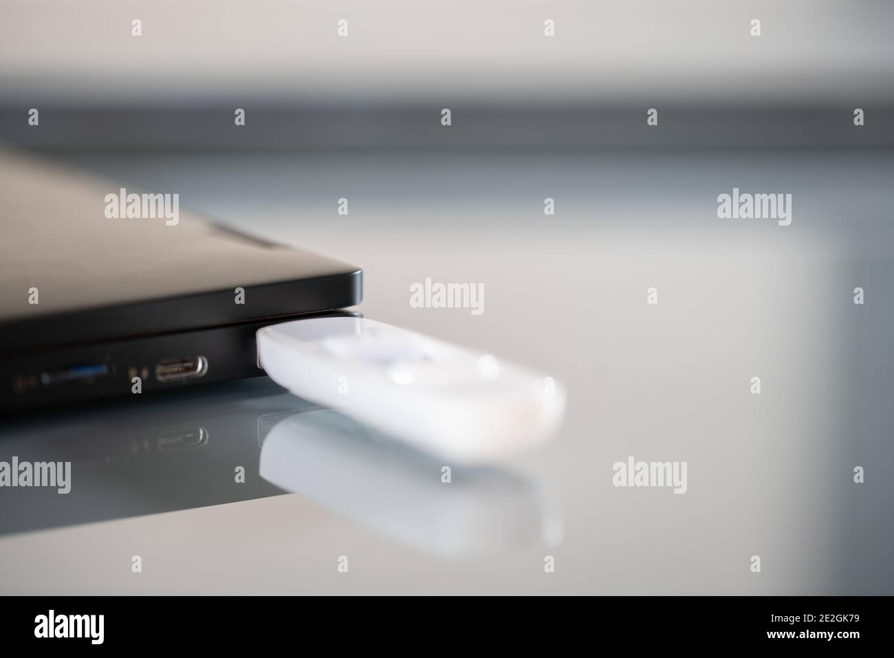 Primo piano del pendrive bianco collegato alla porta USB Foto Stock