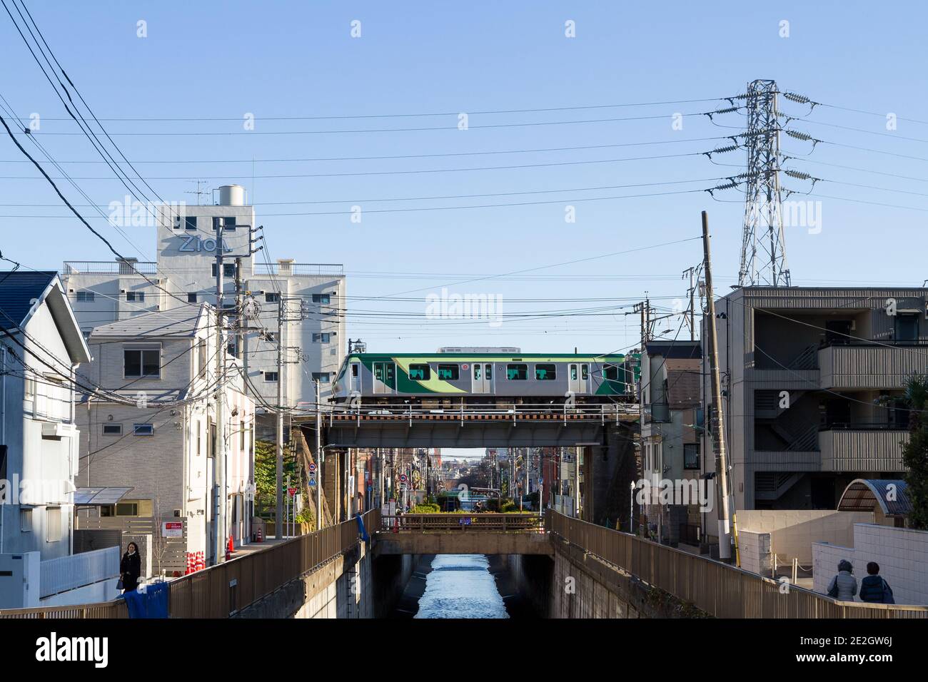 Un treno Tokyu Tamagawa Line serie 7000 su un ponte sopra il fiume Nomi vicino alla stazione di Ishikawa-dai Ota City, Tokyo, Giappone. Foto Stock