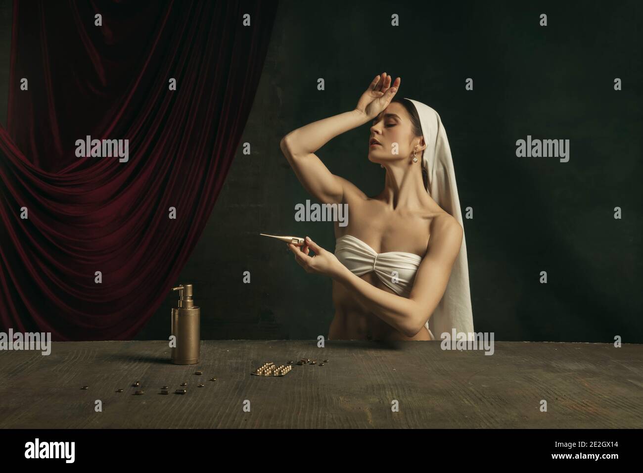 Moderno remake di opere d'arte classica con tema coronavirus - giovane donna medievale su sfondo scuro sente la febbre, prendendo pillole colorate in oro. Concetto di coronavirus, pandemia, creatività. Foto Stock