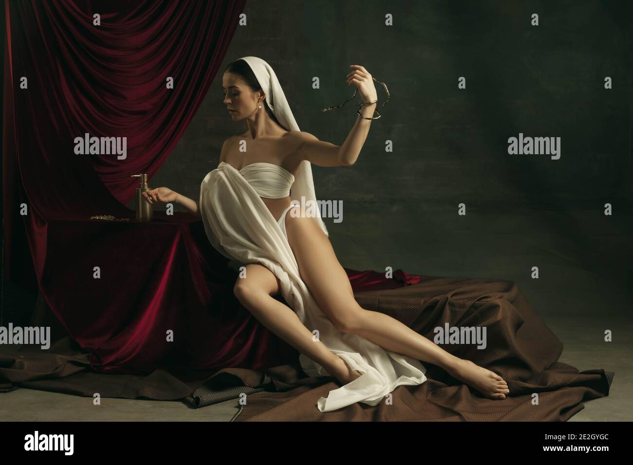 Attenzione. Moderno remake di opere d'arte classica con tema coronavirus - giovane donna medievale su sfondo scuro in posa con serpente di medicina e pillole. Concetto di coronavirus, pandemia, creatività. Foto Stock