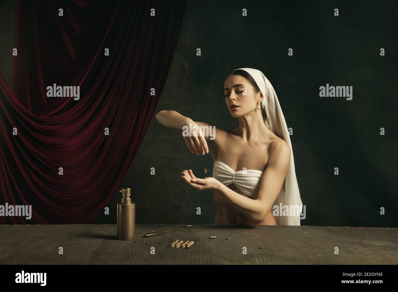 Assistenza sanitaria. Moderna remake di opere d'arte classica con tema coronavirus - giovane donna medievale su sfondo scuro in posa con medicina e pillole. Concetto di coronavirus, pandemia, creatività. Foto Stock