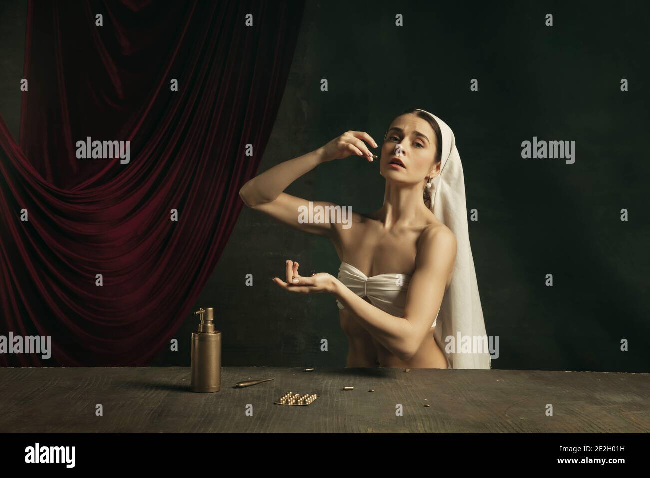 Assistenza sanitaria. Moderna remake di opere d'arte classica con tema coronavirus - giovane donna medievale su sfondo scuro in posa con medicina e pillole. Concetto di coronavirus, pandemia, creatività. Foto Stock