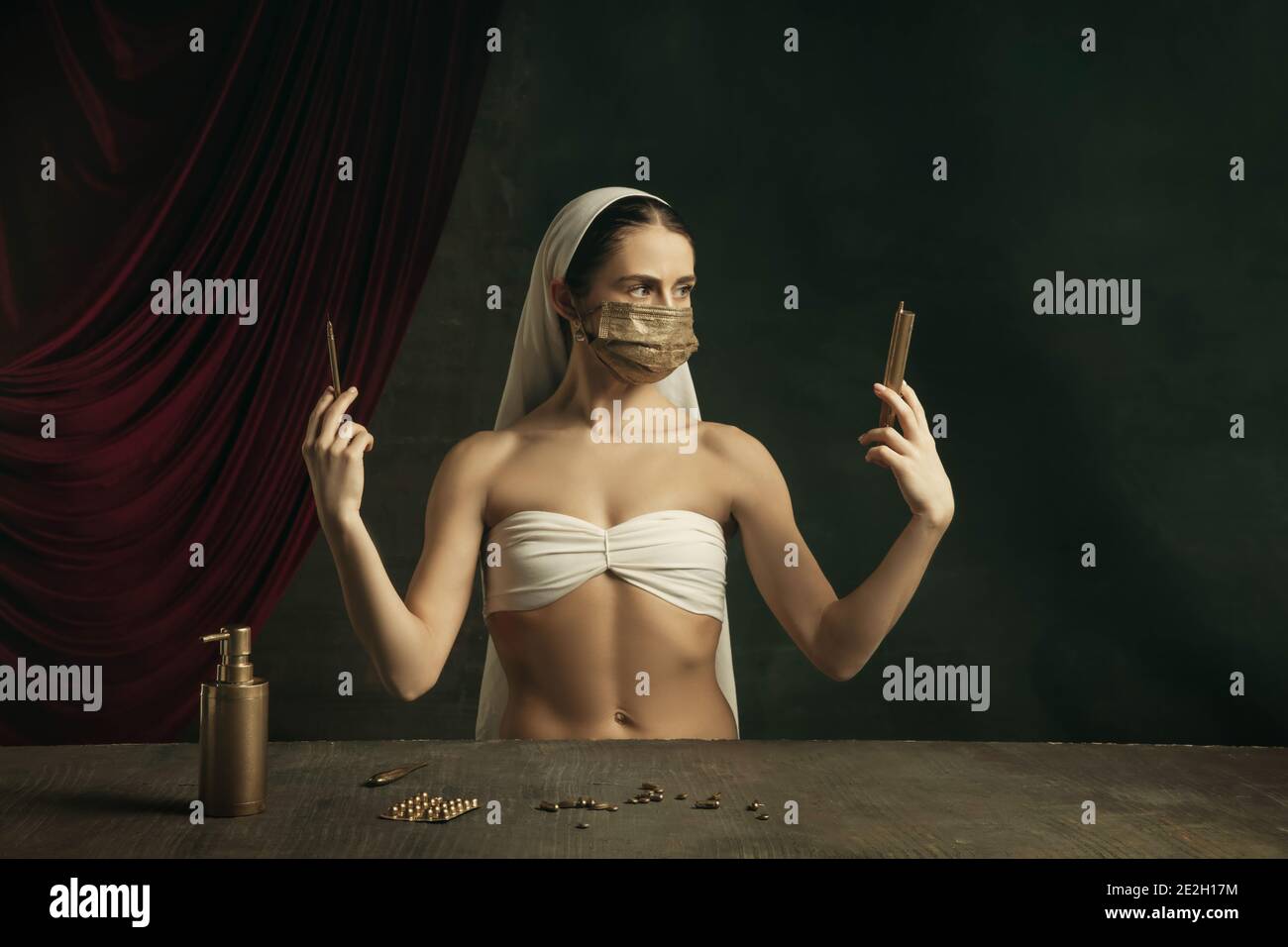 Medico. Moderna remake di opere d'arte classiche con tema coronavirus - giovane donna medievale su sfondo scuro in posa con maschera dorata e medicina. Concetto di coronavirus, pandemia, creatività. Foto Stock
