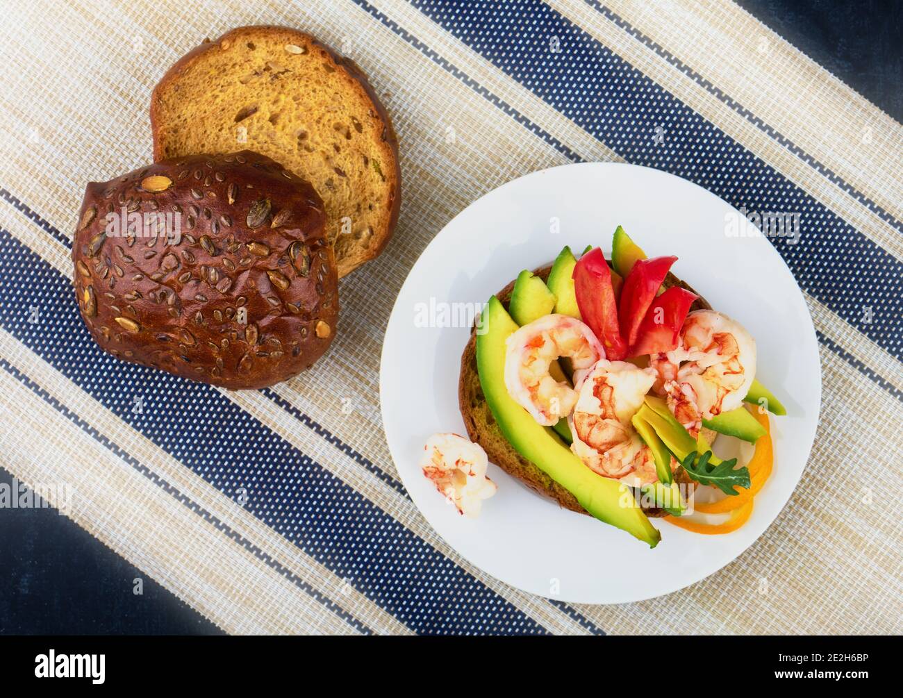 Panino di segale con avocado, gamberi e pomodoro, vista dall'alto, profondità di nitidezza ridotta Foto Stock