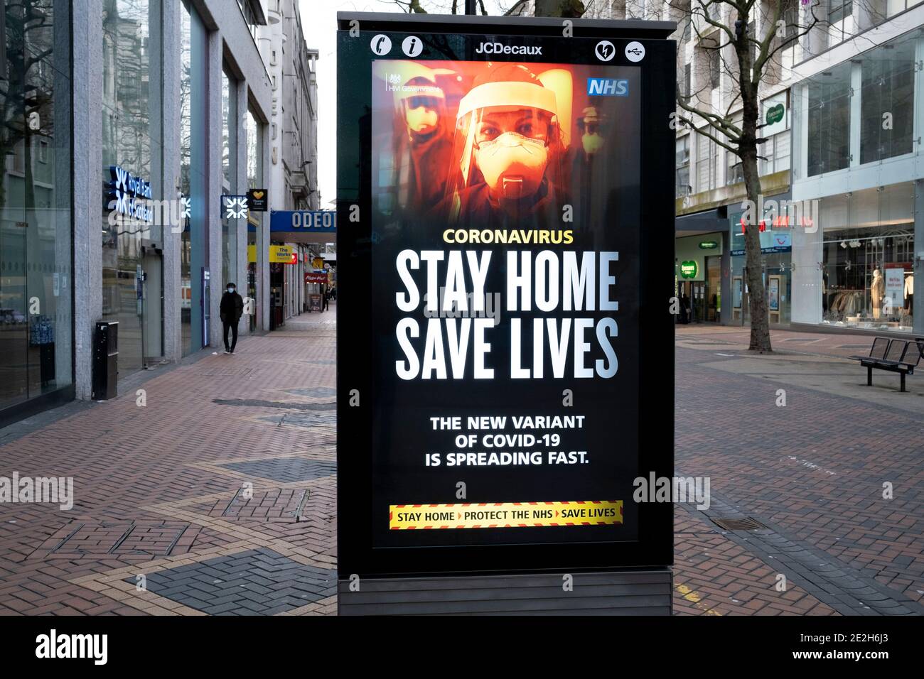 HM Governo, e NHS consigli consigli che la nuova variante si sta diffondendo rapidamente e di rimanere a casa e salvare vite durante il terzo blocco nazionale coronavirus nel centro di Birmingham, che è deserta a parte alcune persone il 12 gennaio 2021 a Birmingham, Regno Unito. A seguito del recente aumento dei casi, tra cui la nuova variante di Covid-19, questo blocco nazionale, che è un efficace Tier Five, è entrato in funzione ieri, con tutti i cittadini a seguire il messaggio di rimanere a casa, proteggere l'NHS e salvare vite. Foto Stock