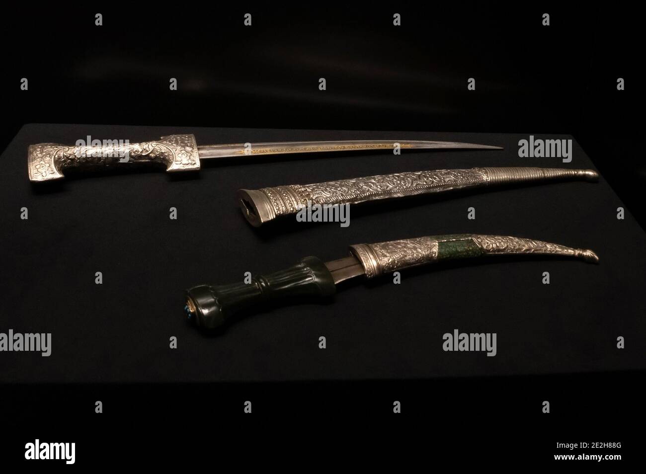 Antico pugnale su sfondo nero di metalli preziosi con elaborate incisioni in scabbards e senza di loro Foto Stock