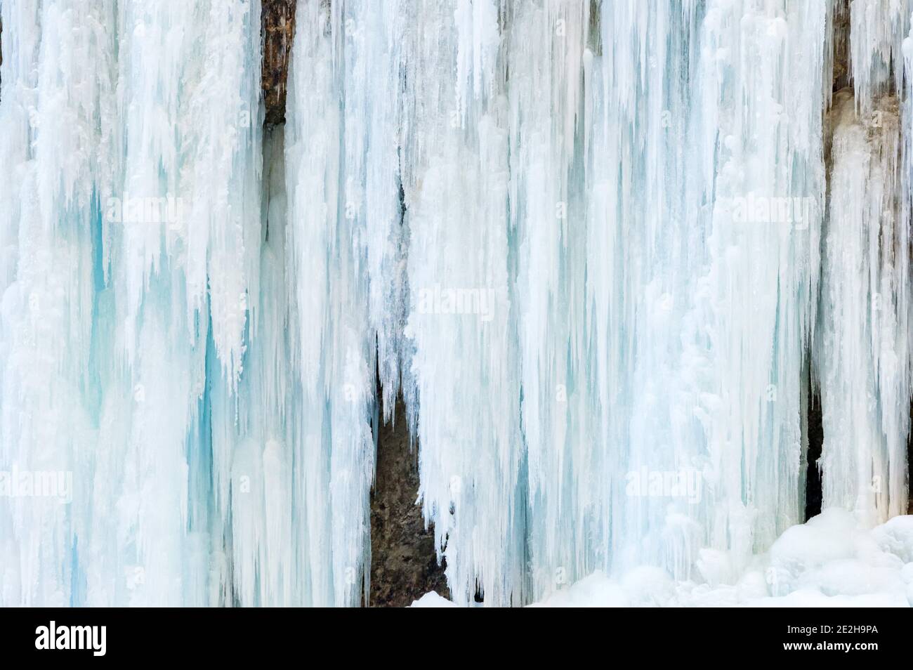 Icicle primo piano con dettagli sulla cascata ghiacciata. Il picchietto di ghiaccio può essere pericoloso. Acqua congelata in grande formazione di gocce lentamente fondendo e gocciolando. Foto Stock