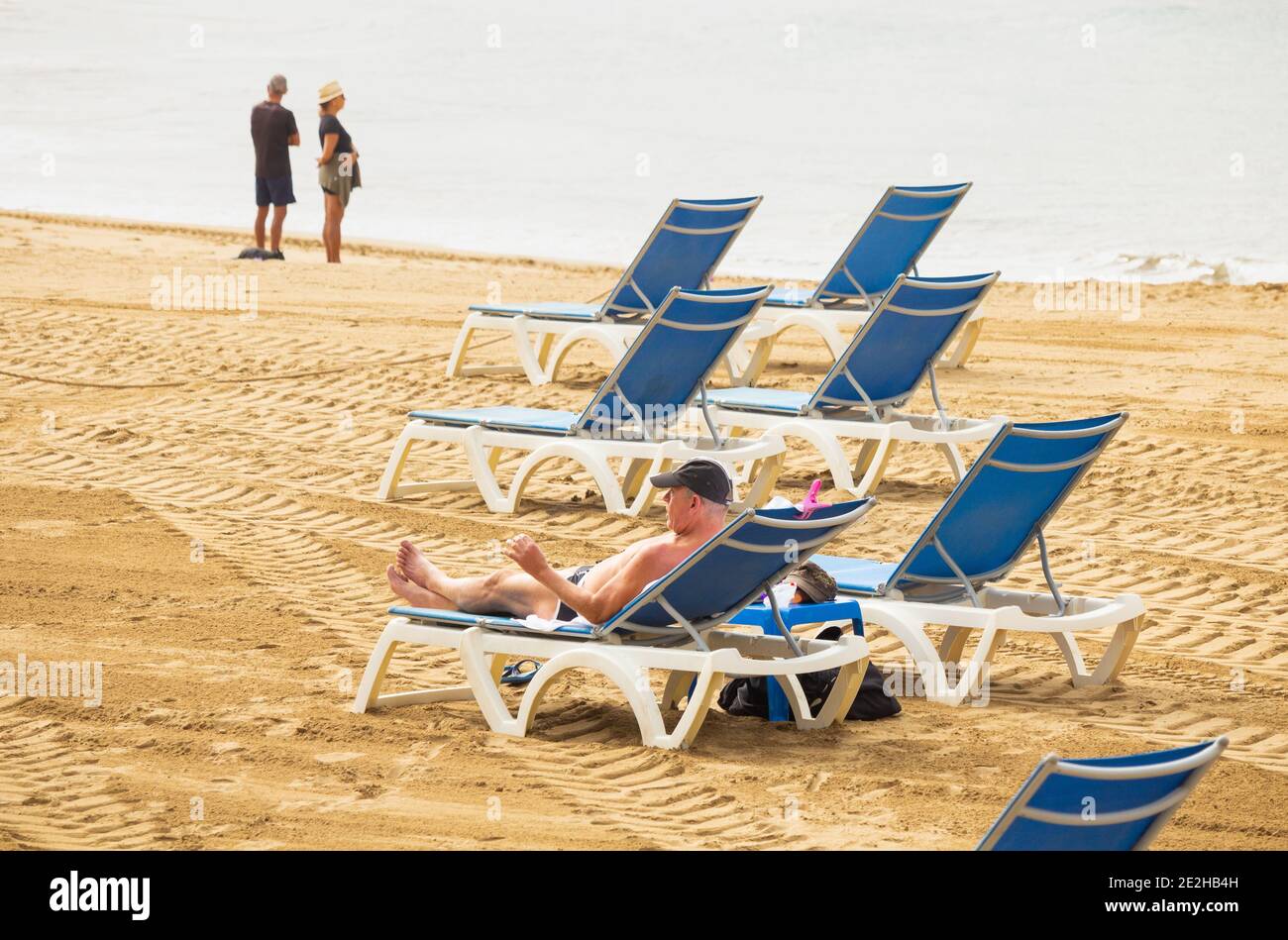 Las Palmas, Gran Canaria, Isole Canarie, Spagna. 14 gennaio 2021. Turisti su una spiaggia molto tranquilla di Las Pamas sulla Gran Canaria. La popolare destinazione invernale del sole per molti turisti britannici sta avvertendo gli effetti del divieto di viaggio del Regno Unito. TUI e altre società di viaggi stanno segnalando un aumento sicuro del vaccino nelle prenotazioni di vacanze per l'estate 2021 da più di cinquanta persone nel Regno Unito. Credit: Alan Dawson/Alamy Live News. Foto Stock