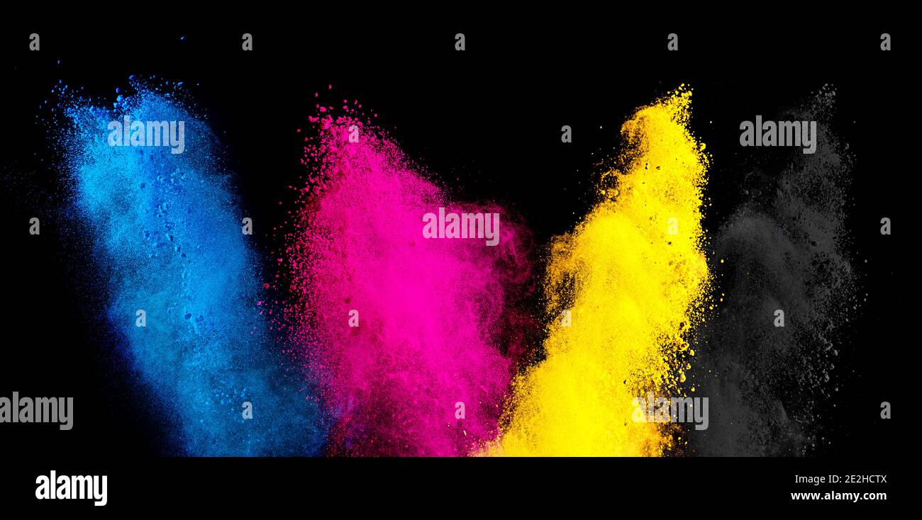 Colore CMYK ciano magenta giallo chiave holi vernice colore polvere esplosione isolato su sfondo nero scuro. Stampa industria di produzione Foto Stock
