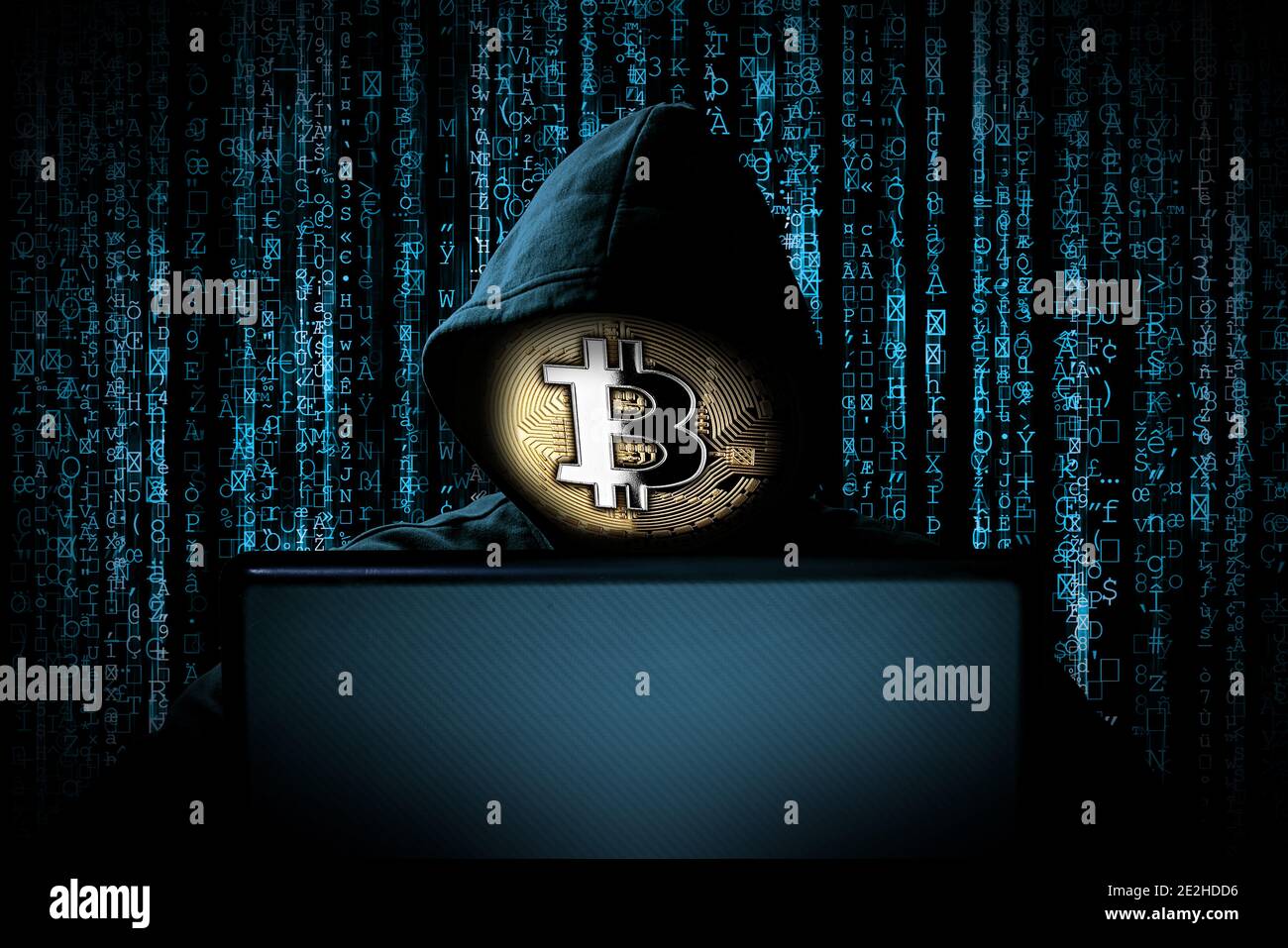 hacker con maschera bitcoin dietro il notebook davanti di codice binario fonte blu sfondo internet cyber hack attacco blocco della valuta crypto Foto Stock