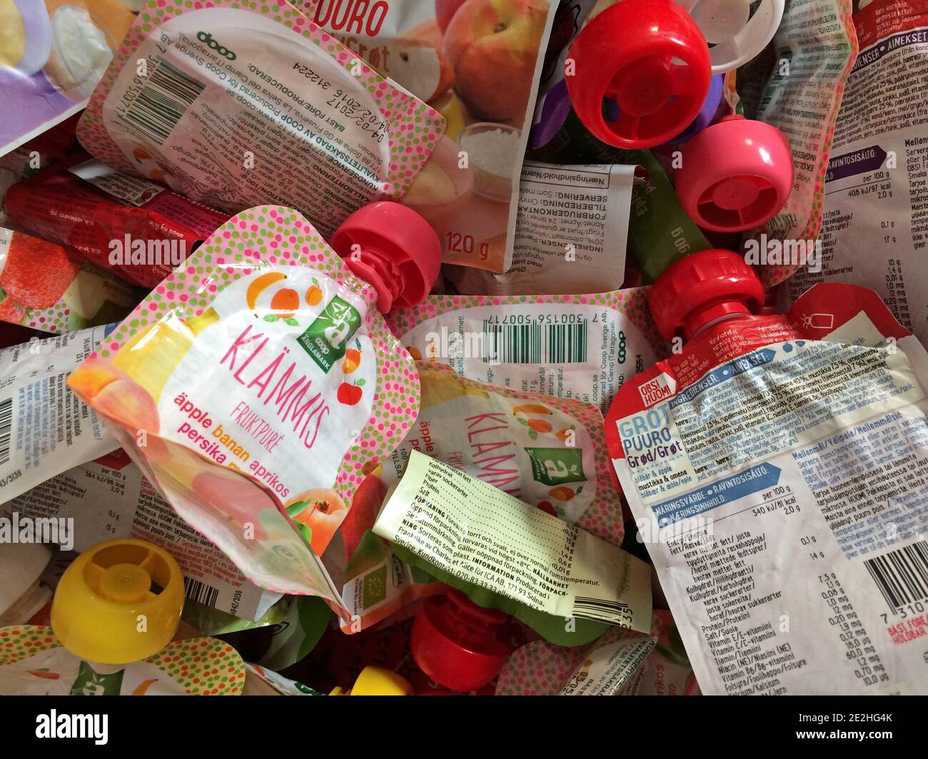 Un sacco di sacchetti per alimenti per bambini pronti per il riciclaggio. Colori diversi e diverse marche di un cibo molto popolare per i bambini. Foto Stock