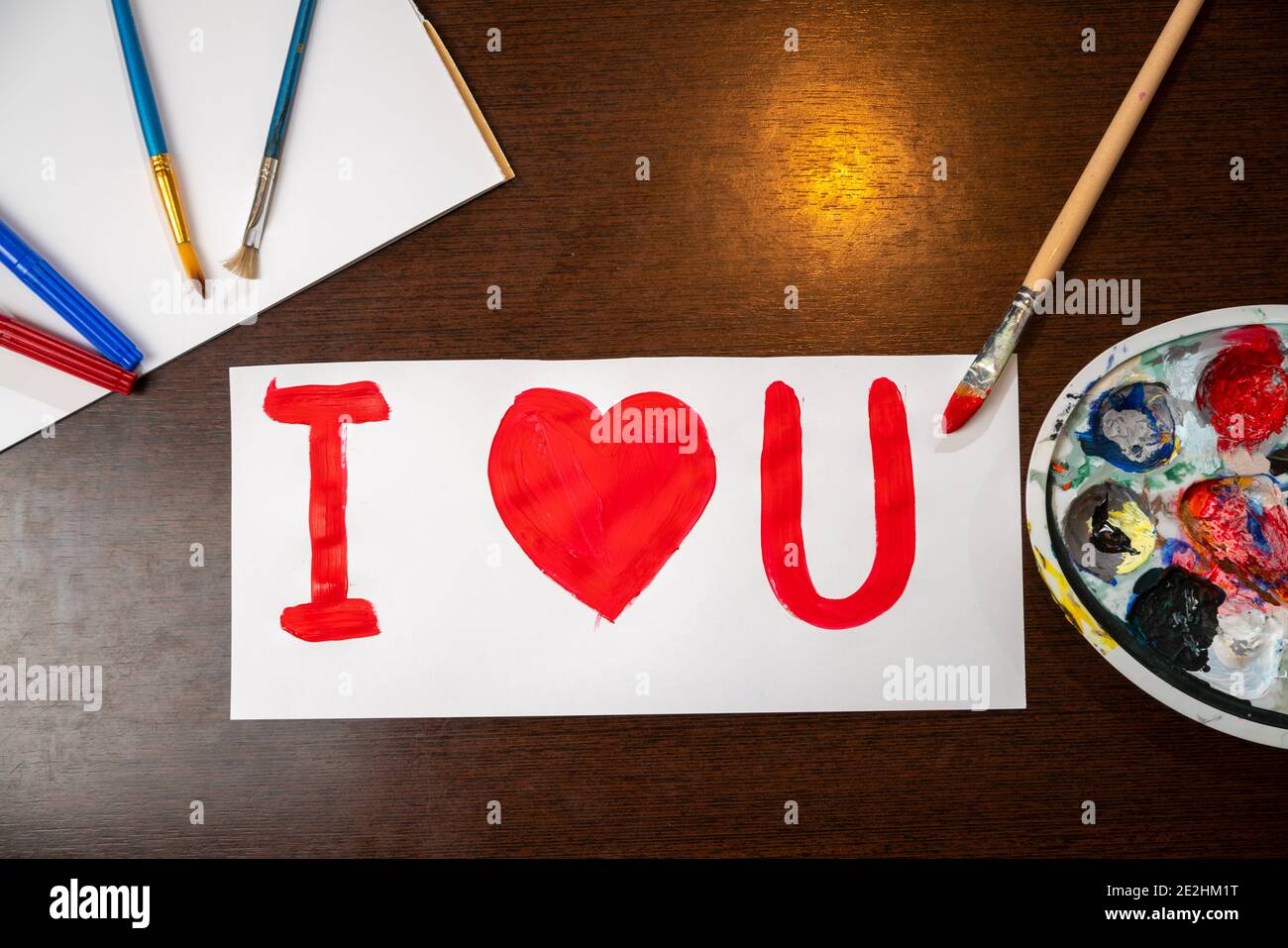 Biglietto d'auguri fatto a mano per il giorno di San Valentino. Ti amo segno dipinto con pennello su carta bianca. Foto Stock