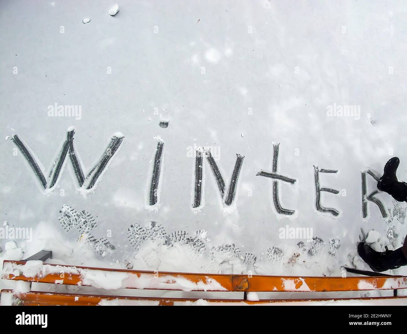 la parola inverno ragazza ha scritto nella neve con lei bagagliaio Foto Stock