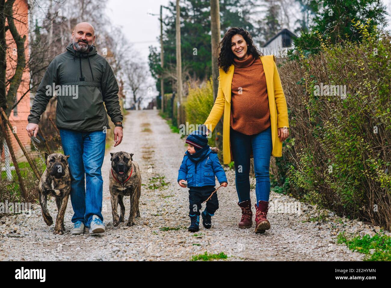 La famiglia sta prendendo un cane per una passeggiata e godendosi attività all'aperto Foto Stock