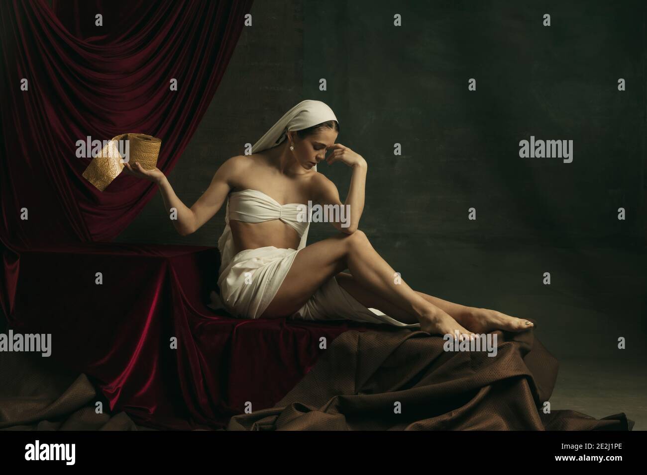 Posa bella. Moderna remake di opere d'arte classiche con tema coronavirus - giovane donna medievale su sfondo scuro con carta igienica dorata. Concetto di coronavirus, pandemia, creatività, arte Foto Stock
