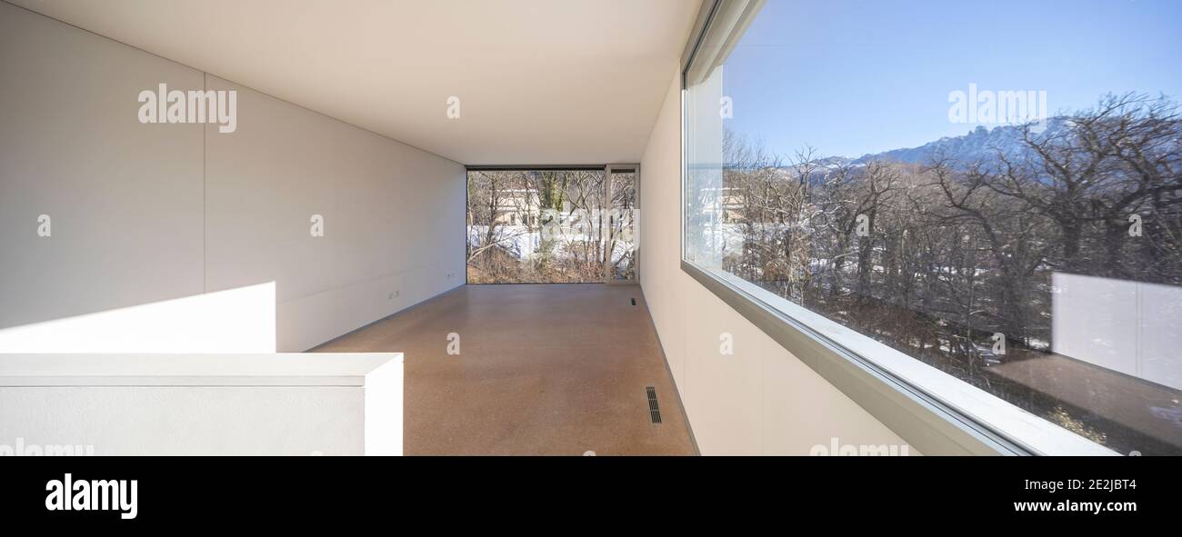 Interno di una singola casa di famiglia, ampio spazio vuoto, con una vista sulla natura, le finestre sono grandi. Foto Stock