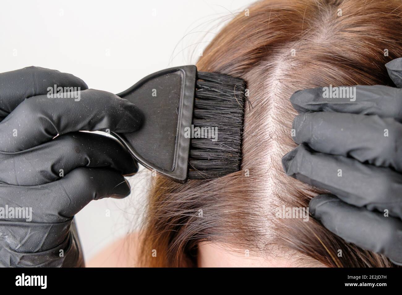 Colorazione delle radici grigie dei capelli a casa. Procedura cosmetica a casa. Foto Stock