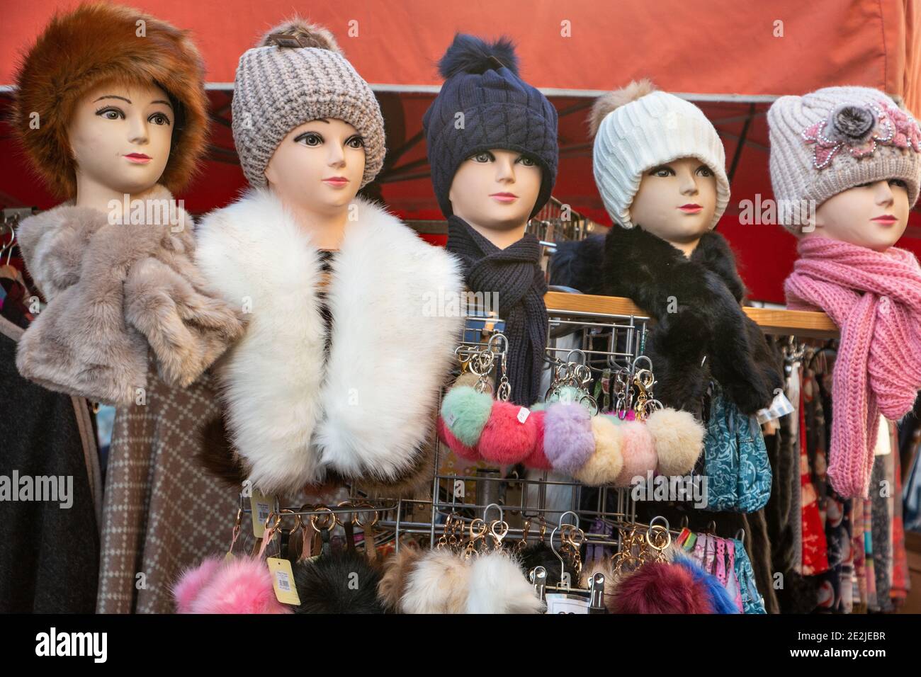 5 teste fittizie con cappelli di lana in fila una bancarella di mercato Foto Stock