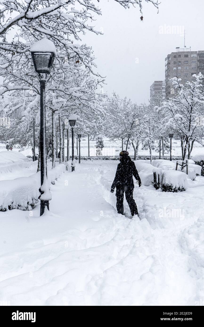 Giovane donna che cammina e che ama le nevicate in un parco a Madrid, Spagna, 2021 Foto Stock