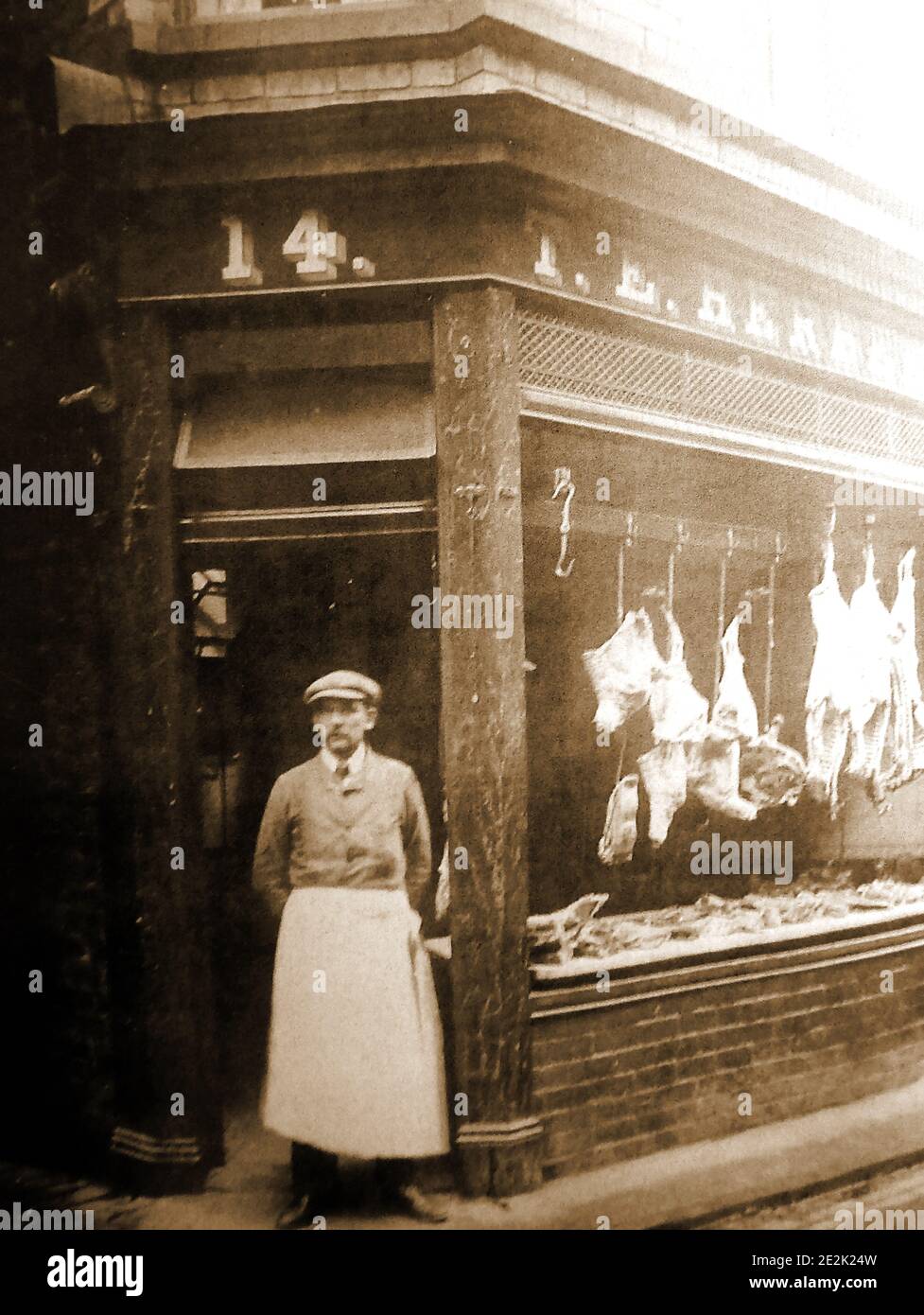 Una prima fotografia di un macellaio tradizionale a Whitby, nel Nord Yorkshire, Inghilterra. La finestra principale del negozio è stata aperta all'aria in modo da mantenere la carne fresca, una tecnica che era comune a quel tempo. Foto Stock
