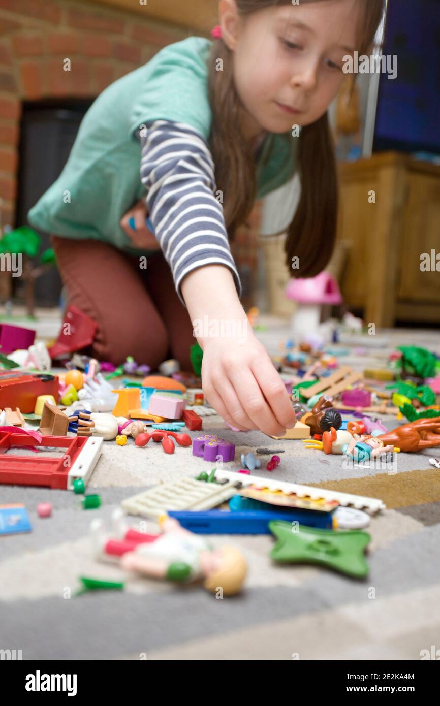 Giovane ragazza che crea con i giocattoli playmobil Foto Stock