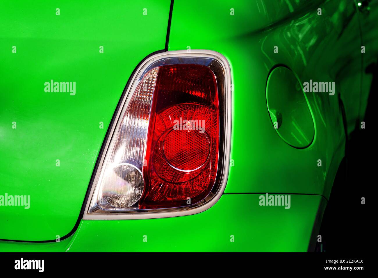 Luce di arresto della luce di posizione posteriore di un'auto elettrica eco in primo piano verde sul retro dell'auto. Foto Stock