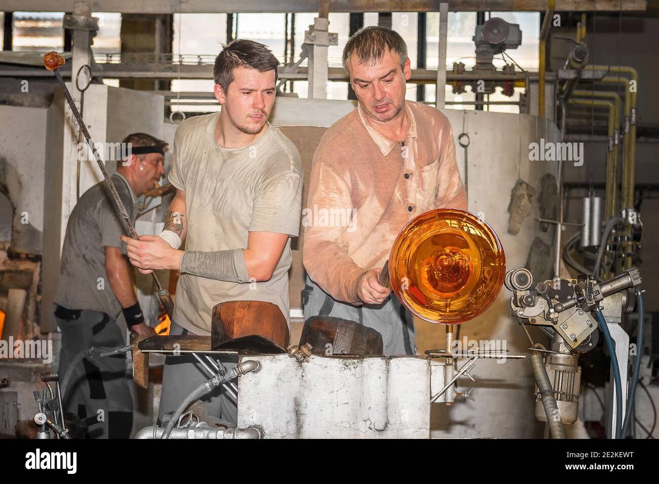 Due vetrerie creative vaso unico in Moser Glass Factory nella Repubblica Ceca. Trasformando una massa calda di vetro disegnata da un forno caldo in un lavoro di a. Foto Stock