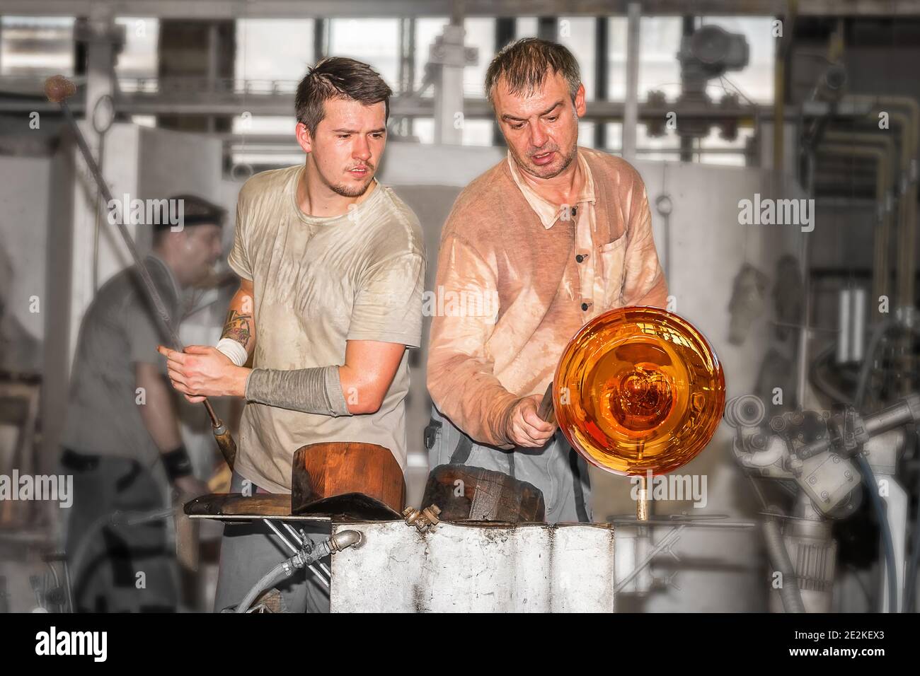 Trasformare una massa calda di vetro prelevata da un forno caldo in un'opera d'arte. Due maestri di vetro nella Moser Glass Factory Foto Stock