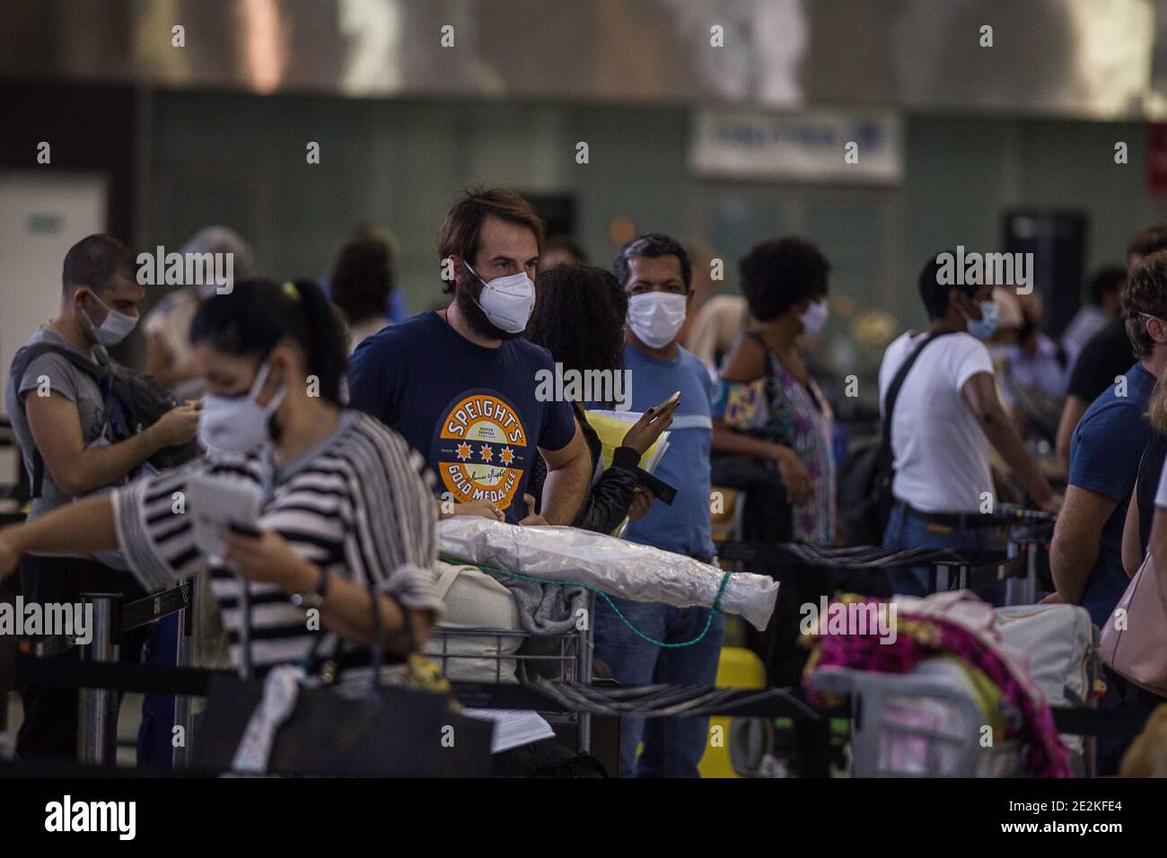 San Paolo, Brasile. 14 gennaio 2021. I passeggeri che indossano maschere si accodano per il check-in all'aeroporto internazionale di Guarulhos dopo che il governo britannico ha imposto un divieto agli arrivi dal Sud America a causa di una nuova mutazione Covid-19. Il divieto del Regno Unito avrà effetto dal 15 gennaio 2021. La nuova mutazione del coronavirus è stata scoperta per la prima volta in Brasile. Credit: Andre Lucas/dpa/Alamy Live News Foto Stock