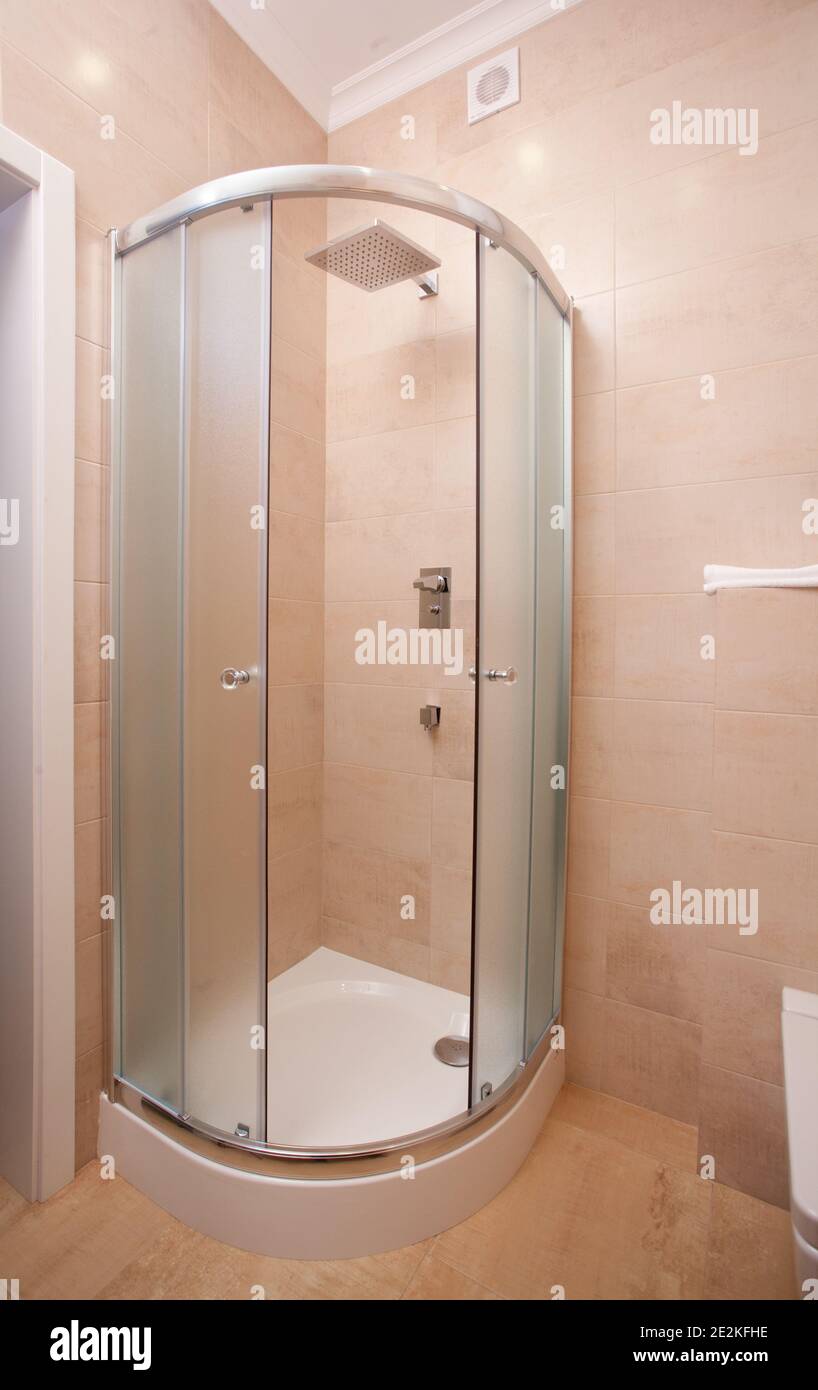 sfondo interno minimalista, bagno di appartamento moderno, cabina doccia in colori chiari, nessuno, con spazio copia, verticale Foto Stock